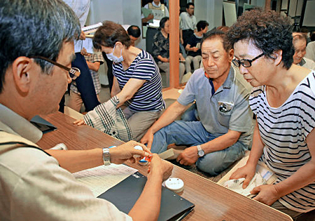 写真（ヨウ素剤の事前配布を受ける住民）　出典：京都新聞 